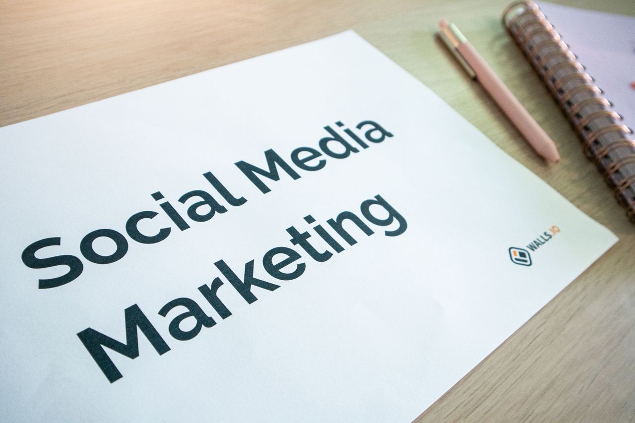 heros-img Vue rapprochée d’un document de marketing sur les réseaux sociaux posé sur un bureau, avec un stylo et un carnet.